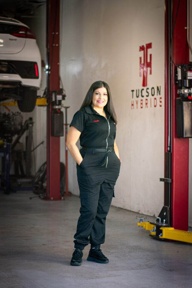 Priscilla Vera, owner of Tucson Hybrids, standing in auto repair shop specializing in hybrid and EV service in Tucson, AZ